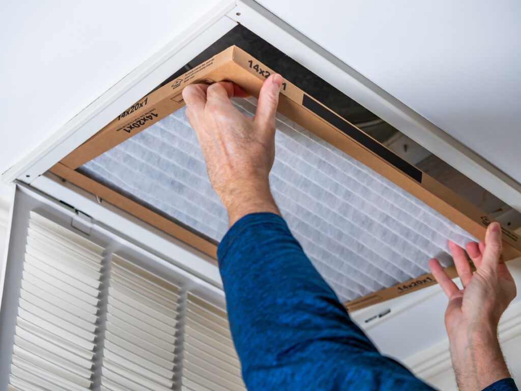 HVAC technician replacing a home air filter in Selma