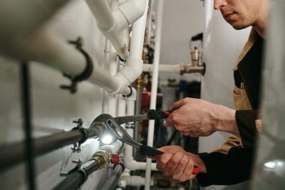 Technician inspecting commercial plumbing pipes in Selma