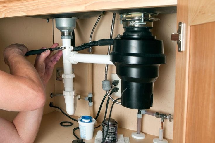 Plumber repairing a garbage disposal in Selma