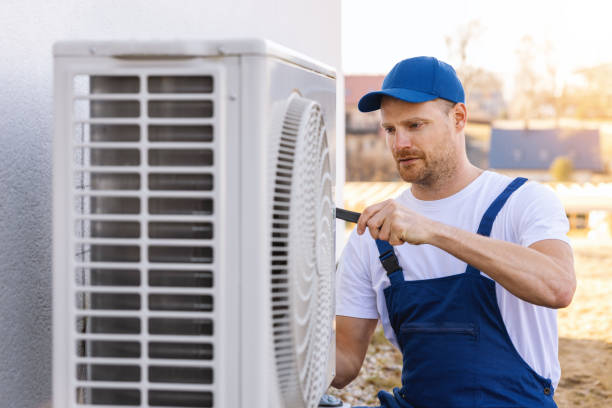 HVAC technician servicing an outdoor air conditioner in Selma