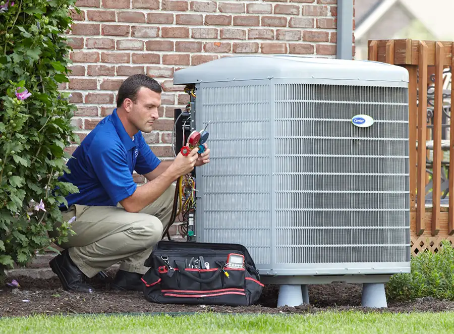 HVAC technician inspecting an outdoor AC unit in Selma